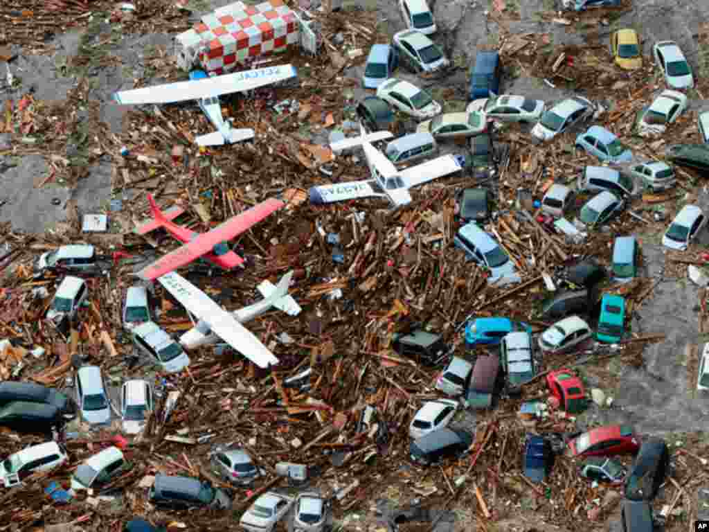 Cars and airplanes swept by a tsunami are pictured among debris at Sendai Airport, northeastern Japan March 11, 2011. A massive 8.9 magnitude quake hit northeast Japan on Friday, causing many injuries, fires and a ten-metre (33-ft) tsunami along parts of 