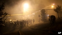 Riot police use light grenades as they confront anti-government protesters, supporters of an armed group who have been holed up inside a police station, in Yerevan, Armenia, July 29, 2016.