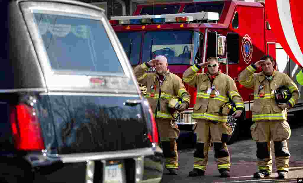2012年12月19日，在康涅狄克州纽敦，桑迪.胡克小学枪击案死难学童、7岁的丹尼尔.杰拉德.巴登的葬礼队伍行进在街上，消防队员向灵车行礼。