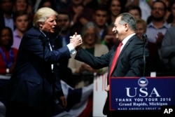 President-elect Donald Trump thanks Dow Chemical Company Chairman and Chief Executive Officer Andrew Liveris during a rally, in Grand Rapids, Mich., Dec. 9, 2016.