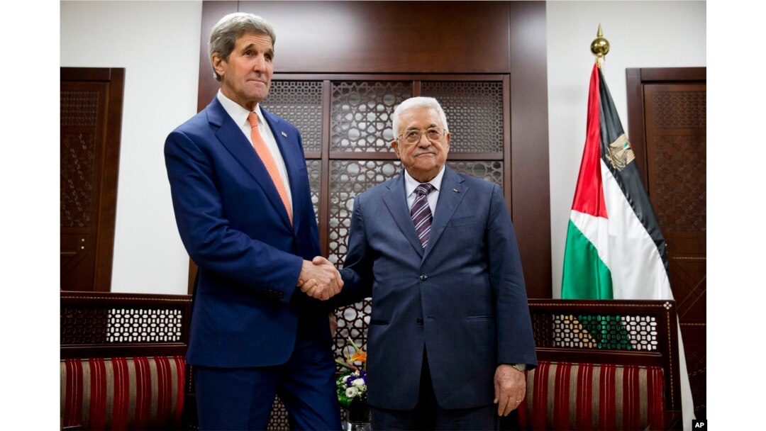 U.S. Secretary of State John Kerry, left, shakes hands with with Palestinian President Mahmoud Abbas at the start of their meeting in the West Bank city of Ramallah, Nov. 24, 2015.