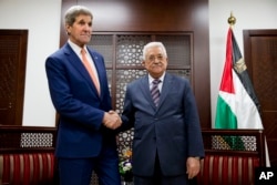 U.S. Secretary of State John Kerry, left, shakes hands with with Palestinian President Mahmoud Abbas at the start of their meeting in the West Bank city of Ramallah, Nov. 24, 2015.