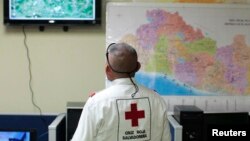 Un miembro de la Cruz Roja de El Salvador observa una pantalla luego de que un terremoto magnitud 7,4 sacudiera el país el lunes por la noche.