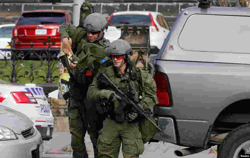 Naoružani pripadnici Kraljevske kanadske konjičke policije prilaze centralnoj zgradi parlamenta u Ottawi, nakon pucnjave 22. oktobra 2014. 