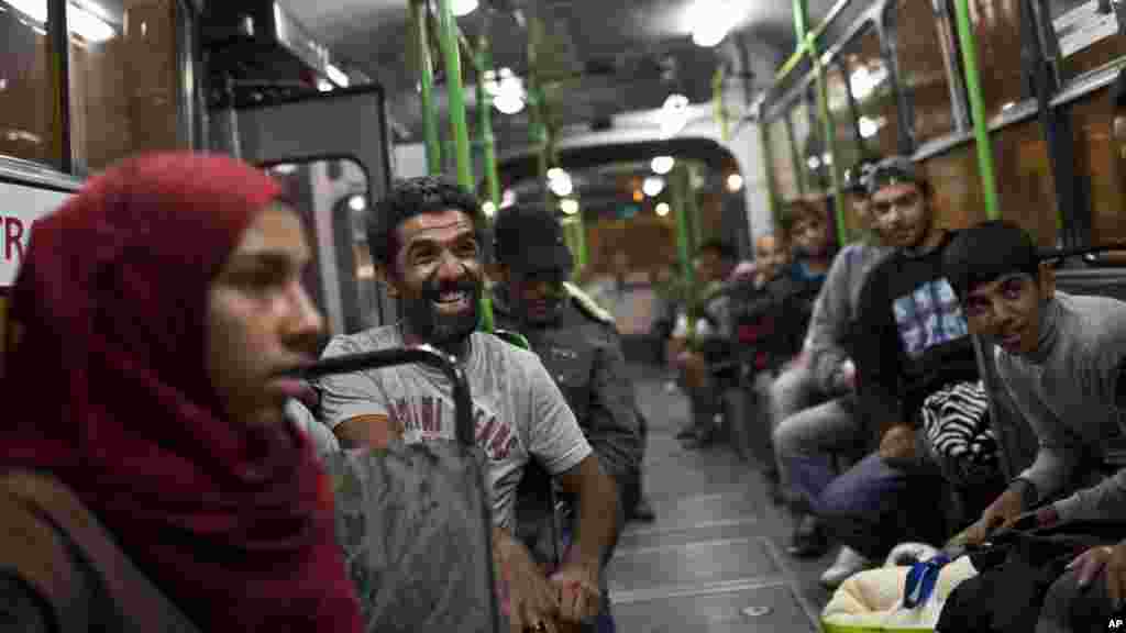 Un homme sourrit, assis dans un dans un autobus fourni par les autorités hongroises pour les migrants et les réfugiés à la gare Keleti à Budapest, 5 septembre 2015