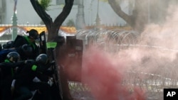 Riot police launch tear gas to protesters marching to Government House in Bangkok, Thailand, July 18, 2021. 