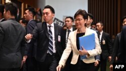 Hong Kong Chief Executive Carrie Lam, right, walks past protesting pro-democracy lawmakers as she arrives for a question and answer session in the Legislative Council in Hong Kong, Oct. 17, 2019.