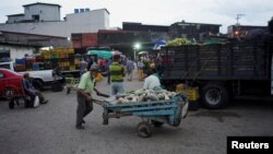 Un hombre empuja un carrito con calabazas afuera de un mercado público en San Cristóbal, Venezuela, el 7 de abril de 2022. 