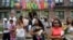 FILE - Flags representing Caribbean nations drape the front of a residential building as people gather outside to watch the annual West Indian Day Parade, celebrating Caribbean heritage, Sept. 1, 2014 in the Brooklyn borough of New York.