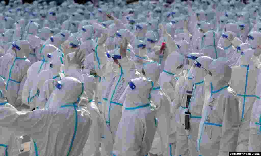 Medical workers in protective clothing wave at Changchun locals during a ceremony before returning to Meihekou, after being sent out to help slow the COVID-19 outbreak in Changchun, Jilin province, China, April 12, 2022.