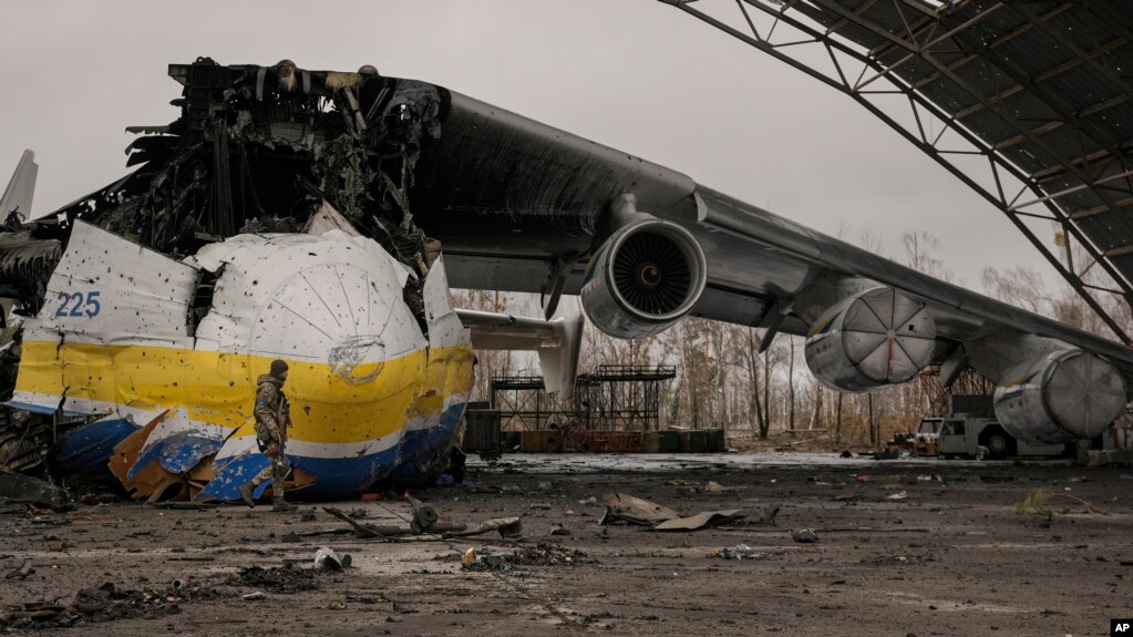 A Ukrainian serviceman walks by the Antonov An-225 Mriya aircraft, destroyed by Russian strikes, at the Antonov airport in Hostomel, Ukraine, April 2, 2022.