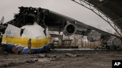 A Ukrainian serviceman walks by the Antonov An-225 Mriya aircraft, destroyed by Russian strikes, at the Antonov airport in Hostomel, Ukraine, April 2, 2022.