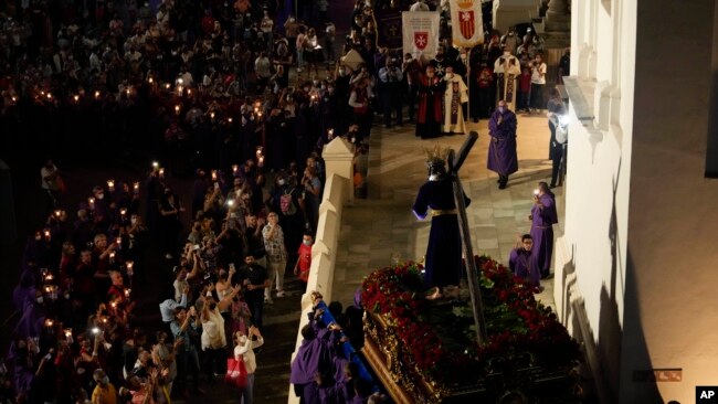 Católicos cargan fielmente una estatua de Jesucristo en una carroza religiosa durante una procesión del Jueves Santo en la Basílica Santa María la Antigua en Ciudad de Panamá, el jueves 14 de abril de 2022. (Foto Arnulfo Franco /AP)
