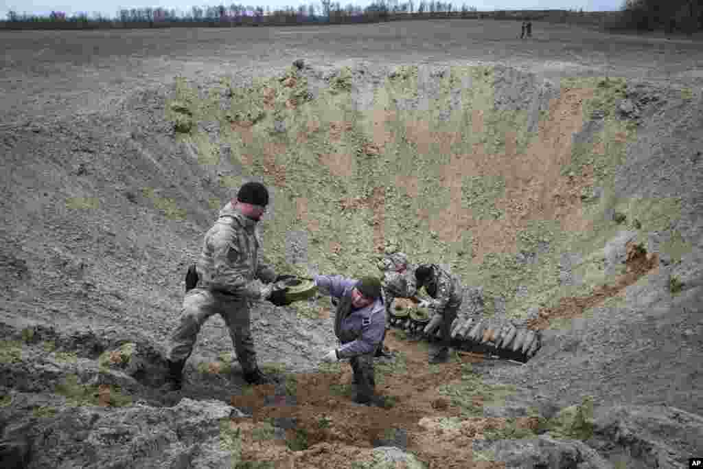 Interior ministry sappers collect explosives in a hole to detonate them near a mine field after recent battles at the village of Moshchun close to Kyiv, Ukraine.