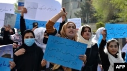 FILE - Afghan women and girls shout slogans demanding the reopening of high schools for girls during a demonstration in front of the Ministry of Education in Kabul, March 26, 2022.