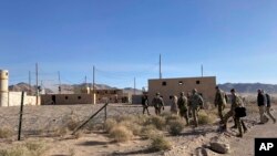 FILE: Army Secretary Christine Wormuth is surrounded by soldiers as she walks toward the fictional town of Ujen at the National Training Center at Fort Irwin, Calif., April 12, 2022.