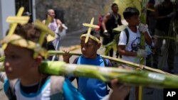 Jóvenes de la hermandad Palmeros de Chacao llevan ramas de palma en la espalda mientras caminan por las calles después de bajar del Cerro Ávila en Caracas, Venezuela, al inicio de la Semana Santa (Foto Adriana Cubillos / AP)