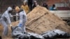 FILE - Men wearing protective gear exhume bodies of some of the civilians killed during the Russian occupation of Bucha, on the outskirts of Kyiv, Ukraine, April 13, 2022.