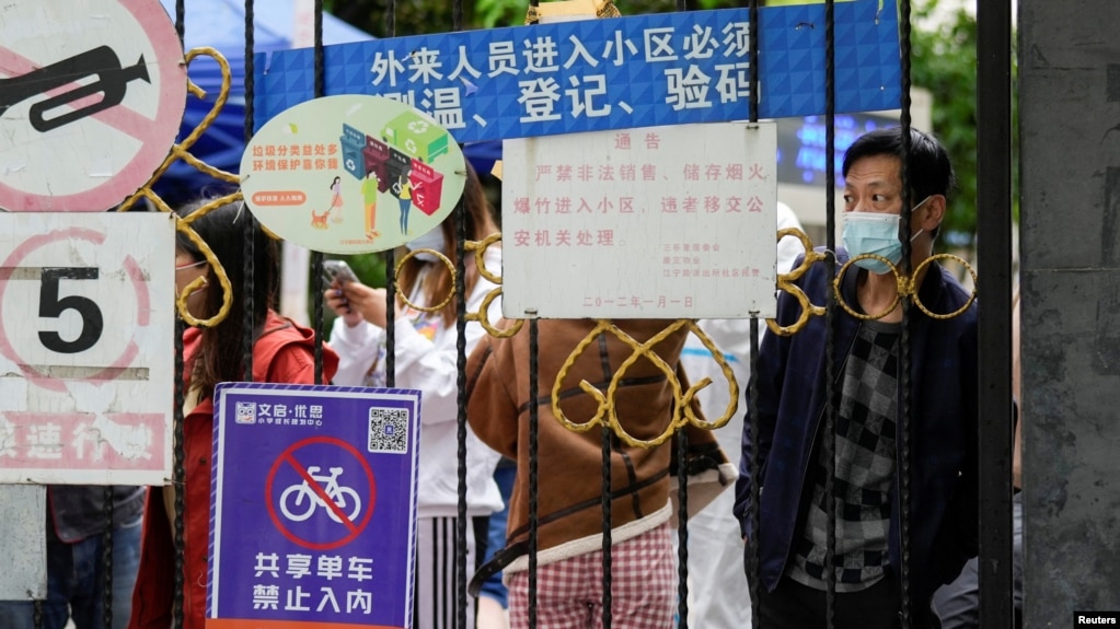 上海封城后居民在关闭的小区大门后等候递送的食物。（2022年4月13日）(photo:VOA)