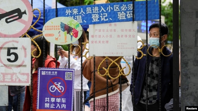 上海封城後居民在關閉的小區大門後等候遞送的食物。 （2022年4月13日）