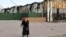 An elderly local resident stands behind a destroyed part of the Illich Iron & Steel Works Metallurgical Plant, the second largest metallurgical enterprise in Ukraine, in an area controlled by Russian-backed separatist forces in Mariupol, Ukraine, April 16, 2022.