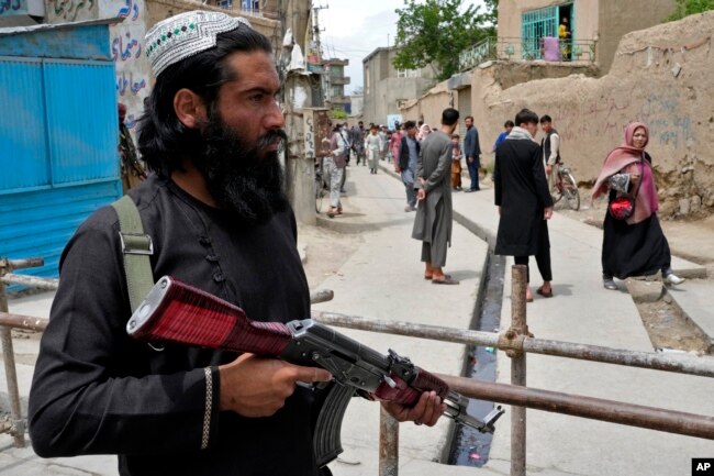 Seorang petugas keamanan Taliban berjaga-jaga di lokasi ledakan di depan sebuah sekolah, di Kabul, Afghanistan, Selasa, 19 April 2022. (AP/Ebrahim Noroozi)
