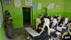 Girls attend a class at their school in Kabul, March 23, 2022. The Taliban prohibition on girls' education shows ultra-conservatives retain control of the Islamist group and exposes a power struggle putting at risk crucial aid for Afghanistan's desperate population.