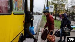 Personas abordan un autobús que sale de Severodonetsk, en la región de Dombás, en el este de Ucrania, el 13 de abril de 2022, cuando las tropas rusas intensificaron una campaña para tomar la ciudad portuaria estratégica de Mariúpol.