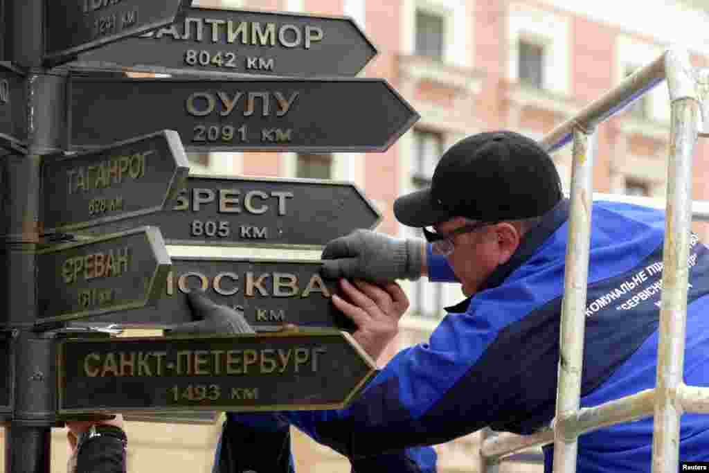 Workers remove plates directing to Russian cities from a street sign in Odesa, Ukraine, amid Russia&#39;s invasion of Ukraine.