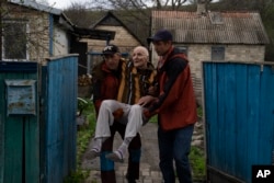 Elderly people are evacuated from a hospice in Chasiv Yar city, Donetsk district, Ukraine, April 18, 2022. At least 35 men and women, some in wheelchairs and most of them with mobility issues, were helped by volunteers to flee from the region that has been under attack in the last weeks.