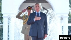 FILE - Pakistan's Prime Minister Shehbaz Sharif gestures during the guard of honour ceremony in Islamabad, April 12, 2022. (Press Information Department handout via Reuters). Journalist Ayaz Amir was assaulted after he gave a speech critical of Sharif, who condemned the assault.