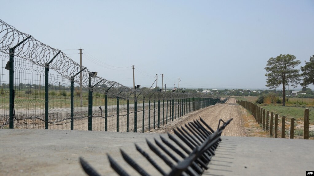 This picture taken on Aug. 15, 2021 shows a barbed wire wall near a police checkpoint, two kilometres from "Friendship Bridge" over the Amu Darya river, which separates Uzbekistan and Afghanistan near Termez.