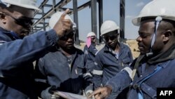 Buruh konstruksi lokal bekerja membangun struktur untuk Proyek Gas Renergen di Afrika pada 22 September 2021. (Foto: AFP)