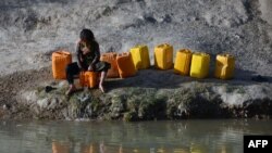 Seorang anak perempuan tampak mengambil air dari kanal Zahir Shahi di Kandahar, Afghanistan, pada 13 April 2022. (Foto: AFP/Javed Tanveer)