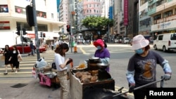 FILE - Women sell street food in Hong Kong, China November 6, 2019. (REUTERS/Thomas Peter)