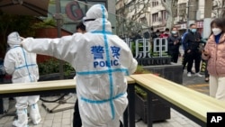 2022年4月1日上海静安区的警察指挥居民排队等待核酸检测。