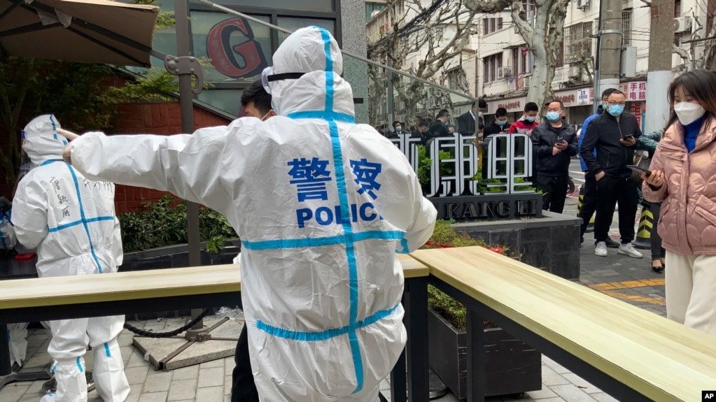 图为2022年4月1日，上海静安区的民警指挥居民排队等待核酸检测。(photo:VOA)