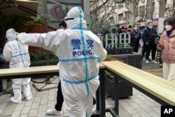 2022年4月1日，上海静安区的警察指挥居民排队等待核酸检测。