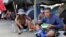 Migrantes cubanos comen en un campamento, instalado por cubanos varados en South Drain mientras esperan el servicio de ferry de Surinam a Guyana, mientras intentan llegar a Estados Unidos, en Nickerie, Surinam, el 11 de diciembre de 2020.