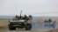 Vehículos militares rusos circulan por una carretera en un área controlada por fuerzas separatistas respaldadas por Rusia cerca de Mariúpol, Ucrania, el 18 de abril de 2022.