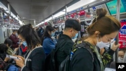 Commuters wearing face masks ride a subway train in Beijing, April 12, 2022. The U.S. has ordered all nonemergency consular staff to leave Shanghai, which is under a tight lockdown to contain a COVID-19 surge.