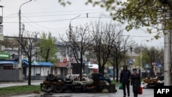 People walk in a street of Severodonetsk, in eastern Ukraine's Donbass region, on April 13, 2022.