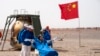 Astronaut China Ye Guangfu duduk di luar kapsul yang membawanya kembali ke bumi dan mendarat di lokasi pendaratan Dongfeng, pada 16 April 2022. Ia baru saja menyelesaikan misi antariksa berawak Shenzhou-13. (Foto: Xinhua via AP/Cai Yang)