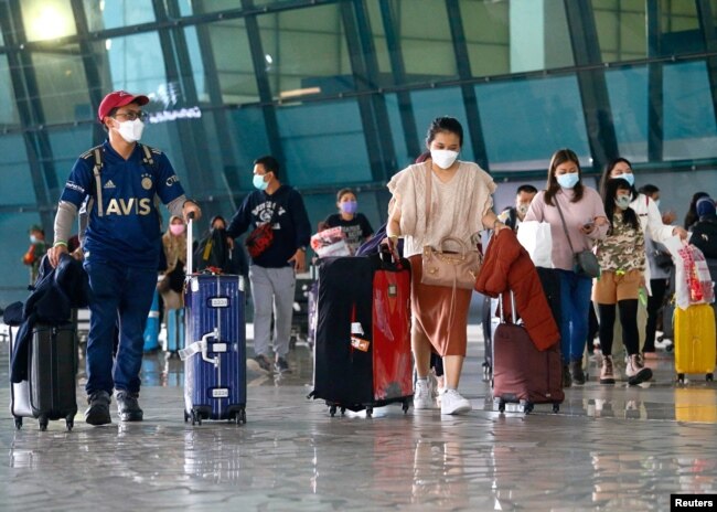 Pelancong berjalan setelah mereka tiba di Bandara Soekarno-Hatta di Tangerang, di pinggiran Jakarta, 1 Januari 2021. (Photo: REUTERS/Ajeng Dinar Ulfiana)