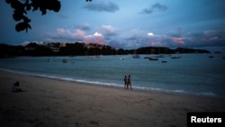 FILE - Tourists walk at a beach in Phuket, Thailand, April 4, 2022. Picture taken April 4, 2022. REUTERS/Athit Perawongmetha