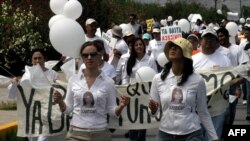 Ciudadanos de Ciudad Juárez marchan en protesta por los asesinatos y desapariciones de mujeres en esta la ciudad fronteriza con Estados Unidos, el 29 de mayo de 2005. 