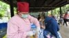 Seorang nakes (kiri) memberikan suntikan vaksin booster Pfizer COVID-19 di Jakarta, 29 Maret 2022. (Foto: ADEK BERRY / AFP)