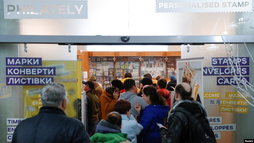 People stand in line to buy postage stamps showing a Ukrainian service member's obscene reaction to a Russian warship at the headquarters of the Ukrainian postal service in Kyiv, April 14, 2022.