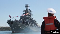 FOTO DE ARCHIVO: Un marinero mira el crucero misilístico ruso Moskva amarrado en el puerto ucraniano de Sebastopol, en el Mar Negro, Ucrania, el 10 de enero de 2013.