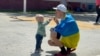 A father blows bubbles with his son on April 6, 2022, at the Benito Juarez sports center in Tijuana, Mexico, that was turned into a refugee center for Ukrainians. 